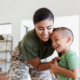 military woman embracing her laughing young son, highlighting support for children during deployment.