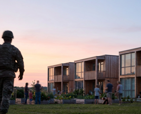 veteran in uniform facing modern housing and community garden at sunset, signifying support for unemployed veterans.