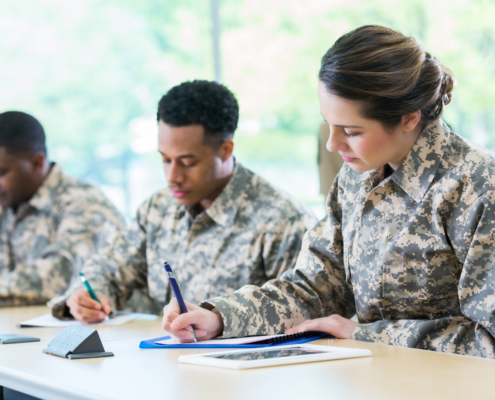veterans in camouflage uniforms taking notes, preparing for civilian careers